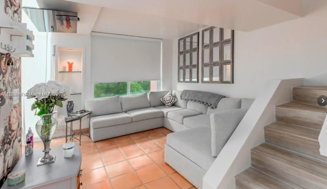 living area featuring stairway and light tile patterned flooring