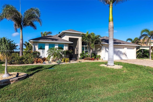 view of front facade with driveway, stucco siding, a garage, and a front yard