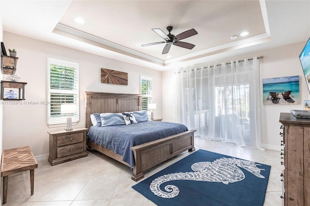 bedroom with baseboards, multiple windows, and a tray ceiling