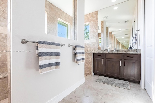 bathroom featuring recessed lighting, vanity, tile patterned flooring, baseboards, and walk in shower