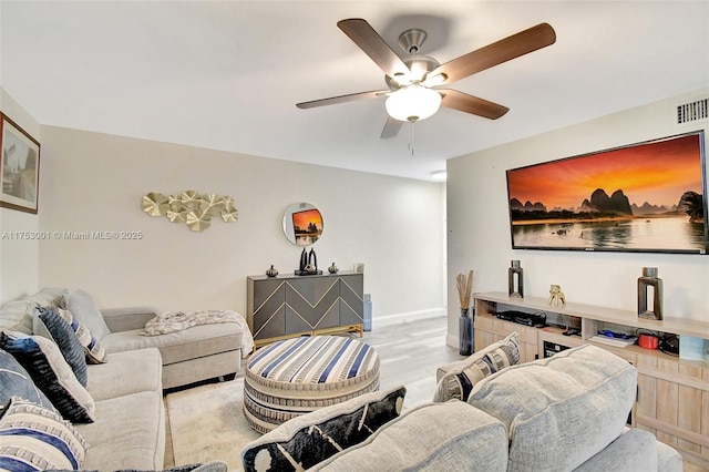 living area with ceiling fan, wood finished floors, visible vents, and baseboards