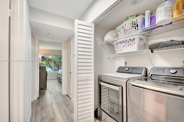 clothes washing area with baseboards, laundry area, independent washer and dryer, and light wood-style floors