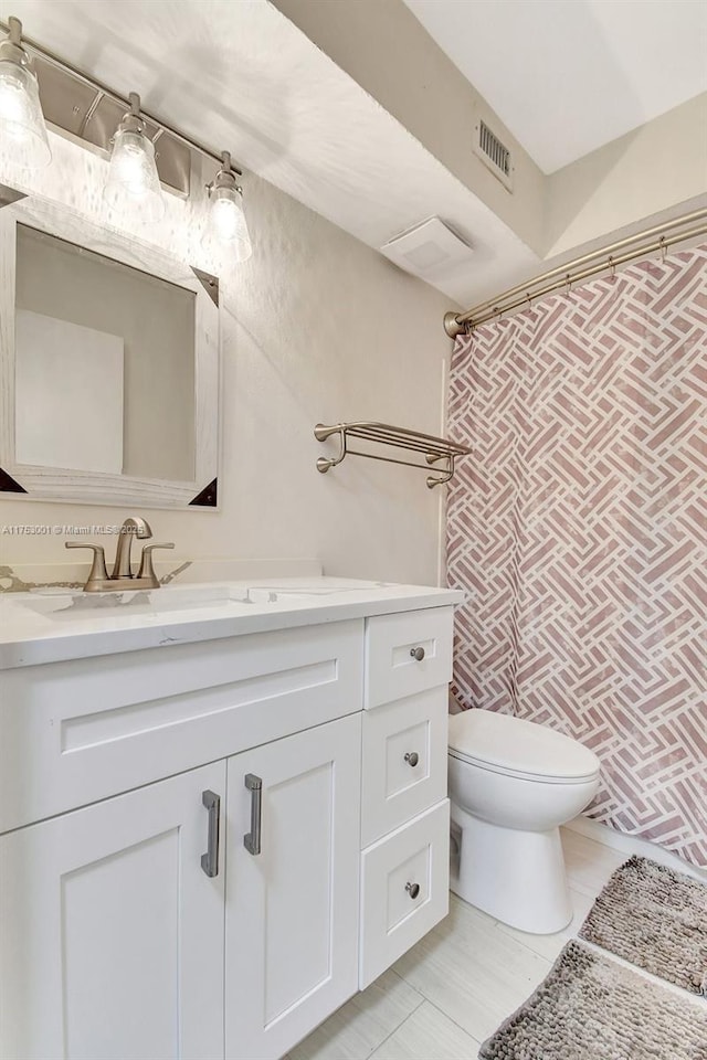 bathroom with toilet, tile patterned floors, visible vents, and vanity