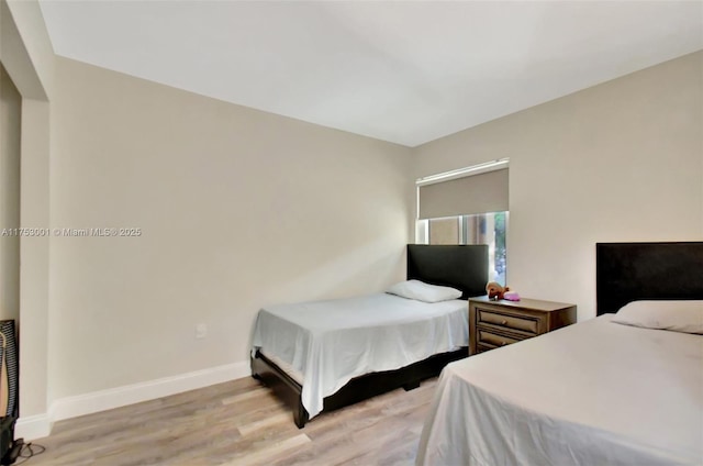 bedroom with baseboards and wood finished floors