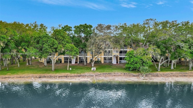 rear view of house featuring a water view and a yard