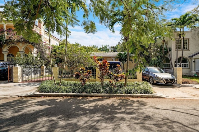 view of front of home with concrete driveway and fence