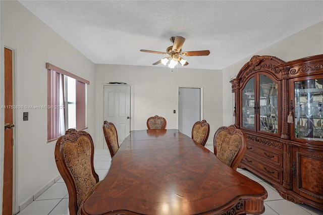 dining room featuring light tile patterned floors, ceiling fan, and a textured ceiling