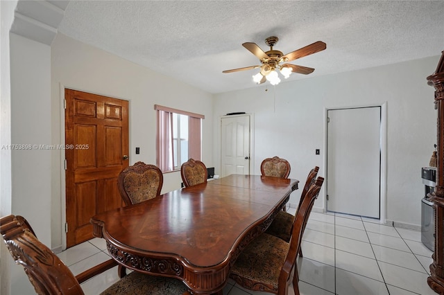 dining area with a ceiling fan, a textured ceiling, and light tile patterned floors