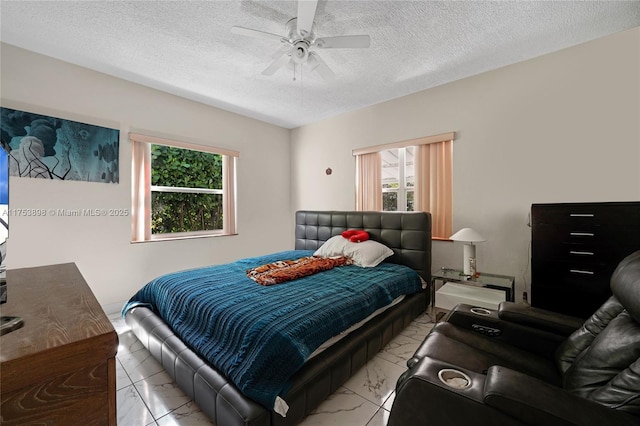 bedroom featuring marble finish floor, a ceiling fan, and a textured ceiling