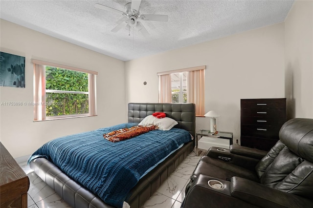 bedroom featuring a textured ceiling, ceiling fan, and marble finish floor