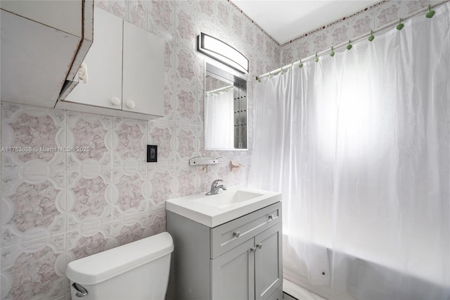 bathroom featuring shower / bath combo, vanity, toilet, and tile walls