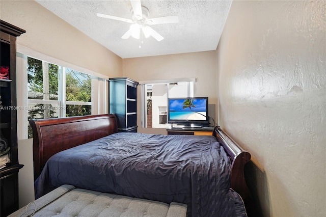 bedroom with ceiling fan, a textured ceiling, and a textured wall