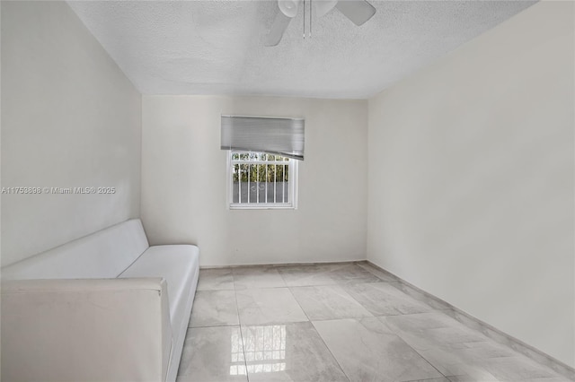 unfurnished room featuring ceiling fan and a textured ceiling