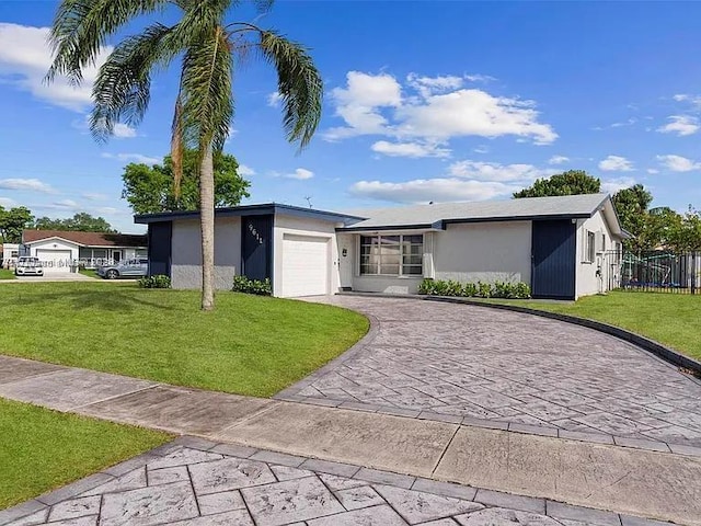 single story home with a garage, fence, driveway, stucco siding, and a front lawn