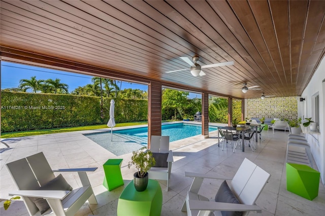 view of patio with a ceiling fan, outdoor dining area, and a fenced in pool