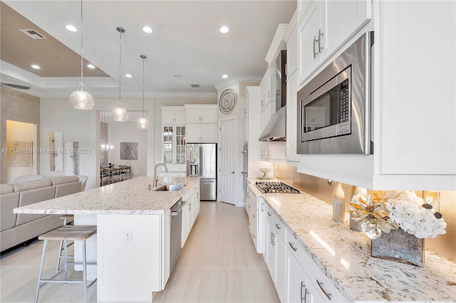 kitchen with stainless steel appliances, a breakfast bar, a sink, visible vents, and open floor plan
