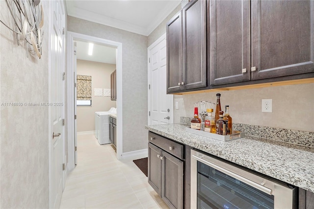 bar featuring tasteful backsplash, baseboards, wine cooler, crown molding, and separate washer and dryer