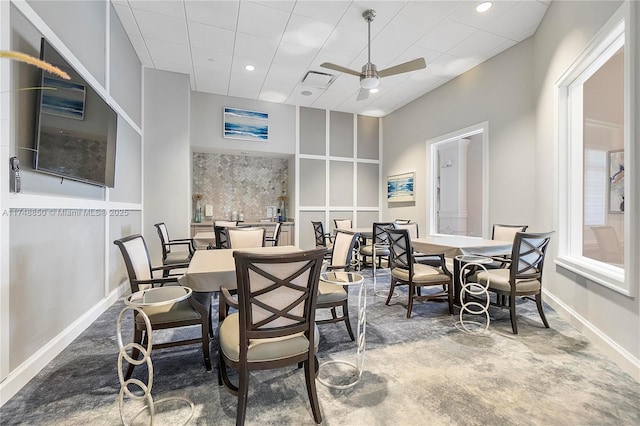 dining space featuring ceiling fan, baseboards, a drop ceiling, and recessed lighting