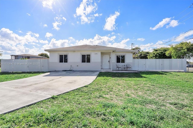 view of front of property featuring fence, a patio, a front lawn, and stucco siding