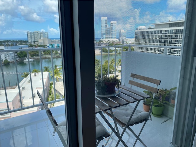 balcony featuring a water view and a city view