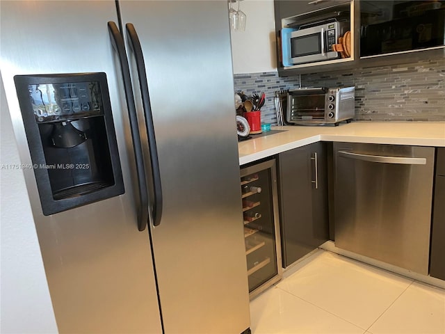 kitchen with a toaster, tasteful backsplash, appliances with stainless steel finishes, and light countertops