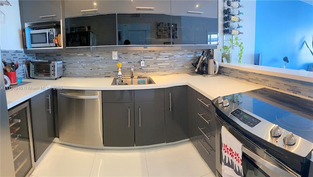 kitchen featuring stainless steel appliances, a toaster, a sink, and decorative backsplash