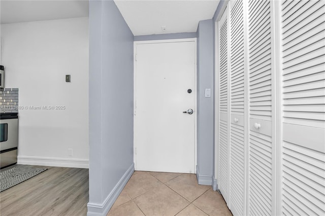 hall with light tile patterned floors and baseboards