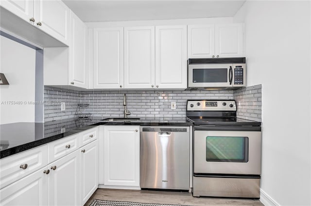 kitchen featuring stainless steel appliances, light wood-type flooring, white cabinetry, and a sink