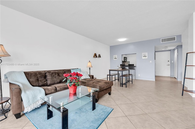 living area with light tile patterned floors, baseboards, and visible vents