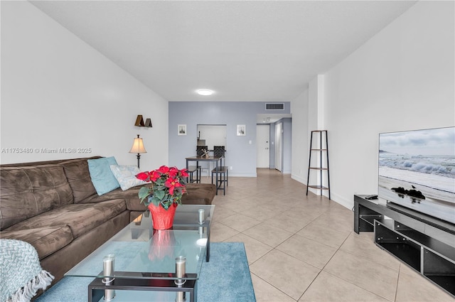 living area with light tile patterned floors, visible vents, and baseboards