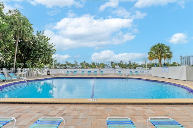 community pool featuring fence and a patio