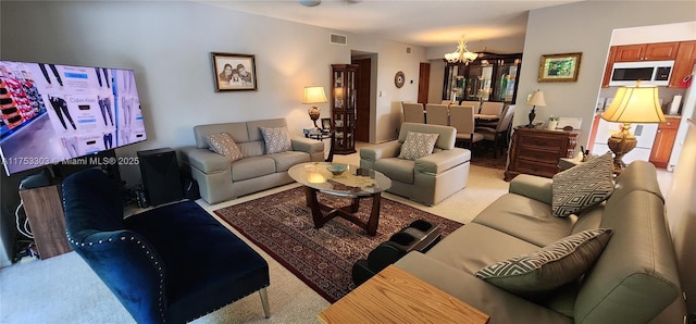 living room featuring carpet flooring, visible vents, and a notable chandelier