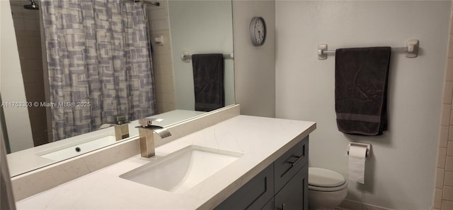 bathroom featuring vanity, a tile shower, and toilet