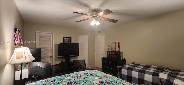 bedroom with ceiling fan, a textured ceiling, a closet, and visible vents