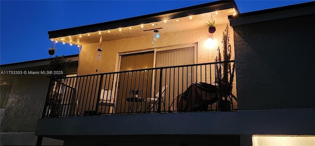 property exterior at night featuring stucco siding