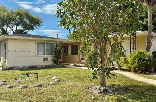 view of front of home featuring a front yard and stucco siding