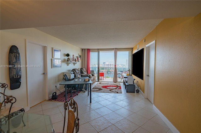 interior space with light tile patterned floors, baseboards, and a wall of windows