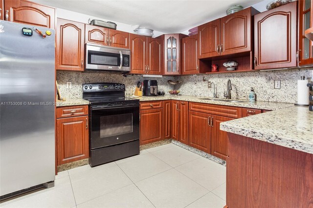 kitchen featuring tasteful backsplash, stainless steel appliances, a sink, and light tile patterned flooring