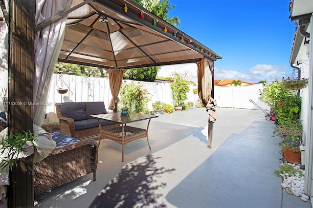 view of patio featuring a gazebo, outdoor lounge area, and a fenced backyard