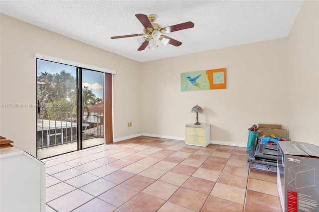 unfurnished room featuring light tile patterned floors, baseboards, and a textured ceiling