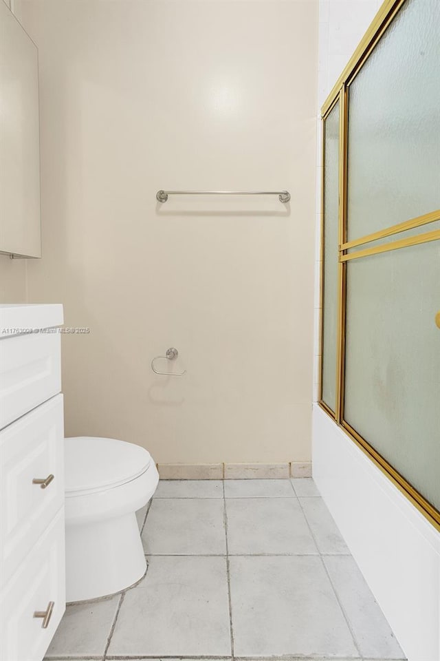 bathroom with enclosed tub / shower combo, toilet, vanity, baseboards, and tile patterned floors