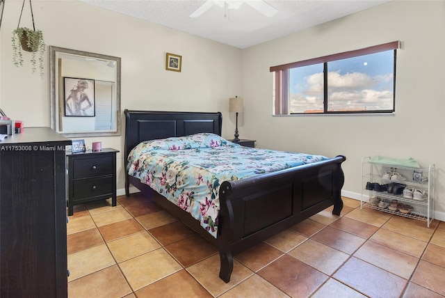 bedroom featuring light tile patterned floors, a textured ceiling, and baseboards