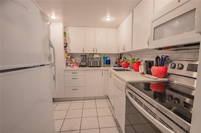 kitchen featuring light countertops, white appliances, a sink, and white cabinets