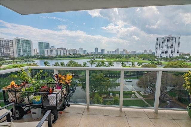 balcony featuring a water view and a city view