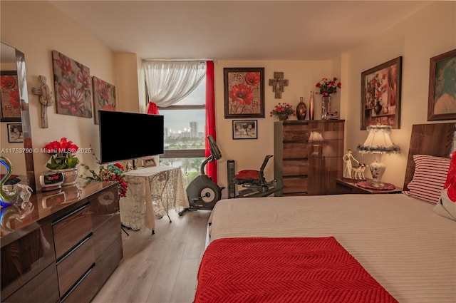 bedroom with multiple windows and wood finished floors