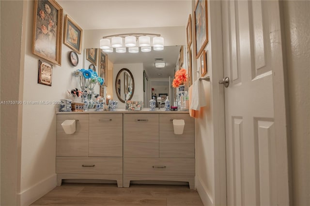 bathroom featuring baseboards, wood finished floors, and vanity