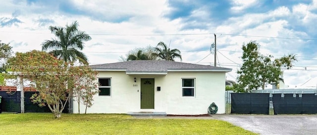 view of front of home featuring a front yard, fence, and stucco siding