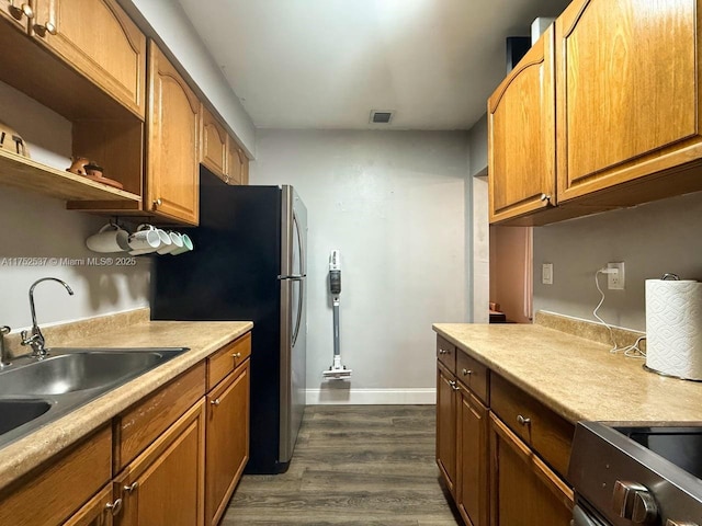 kitchen featuring dark wood-style floors, light countertops, a sink, and visible vents