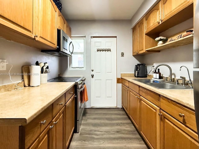 kitchen featuring stainless steel appliances, light countertops, a sink, and dark wood-style floors