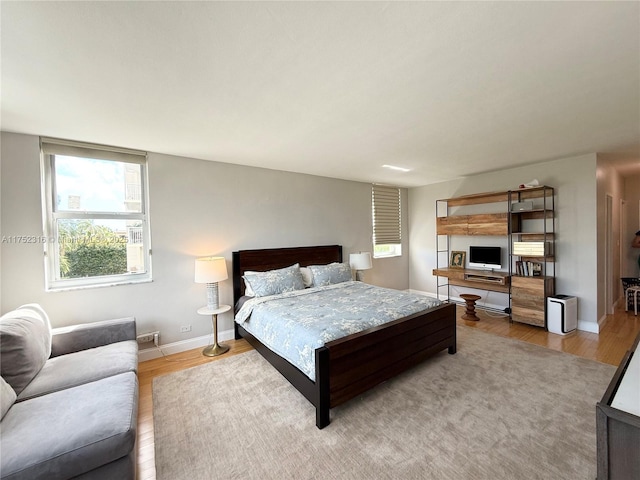 bedroom with baseboards and wood finished floors